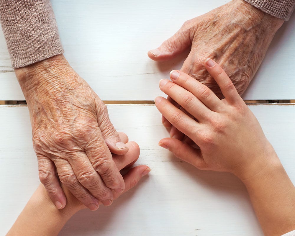 Elderly hands and child's hands touching